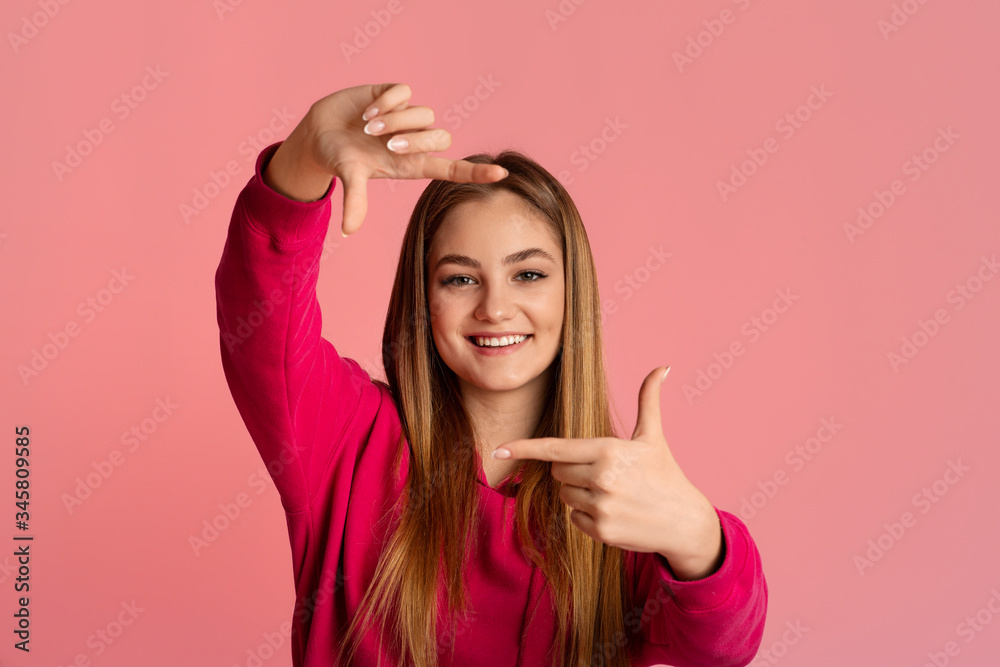 Smiling teenage girl makes photo with hands Smiling teenage girl makes photo with hands