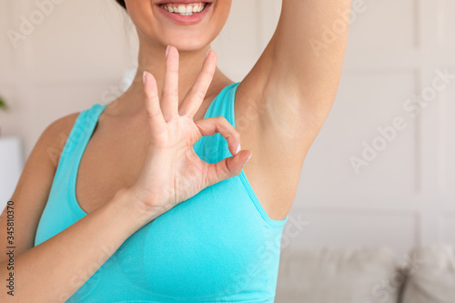 Unrecognizable Girl Showing Shaved Underarm Gesturing Okay At Home, Cropped photo