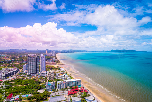 The beautiful blue swimming pool on the top roof of building with blue sea and blue cloudy sky background. 