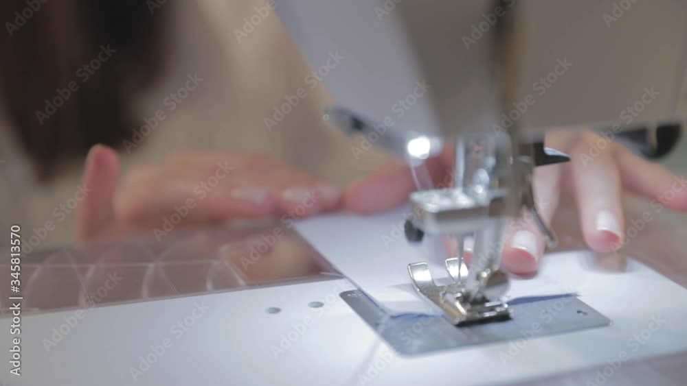 Close-up slow motion video of work of the master seamstress and needle of the automatic sewing machine, good manicure, camera moves around