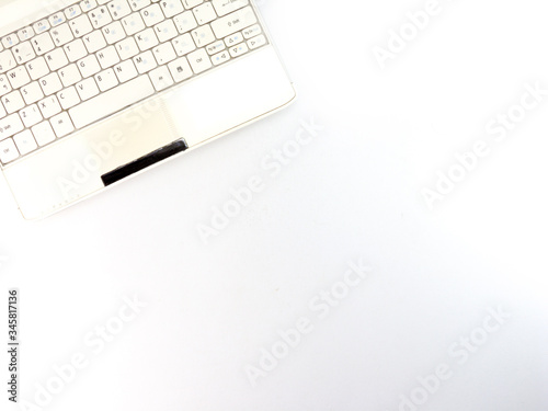 Top view of white laptop closeup on white background.