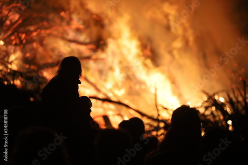 A silhouette of a child watching a large fire