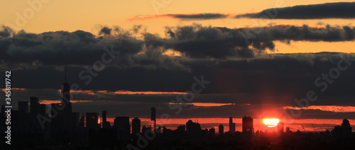 Zachód słońca  nad miastem New York, z groźnymi, ciemnymi chmurami