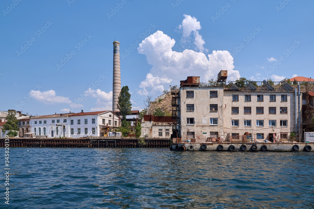 Sevastopol - August 9, 2016: Industrial factory territory, brick pipe, view from the sea