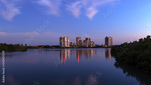 Obraz na plátně Night falls after sunset over Clam Pass as the lights of the highrise buildings