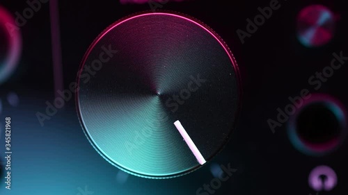 volume knob adjusting in colorful light macro closeup