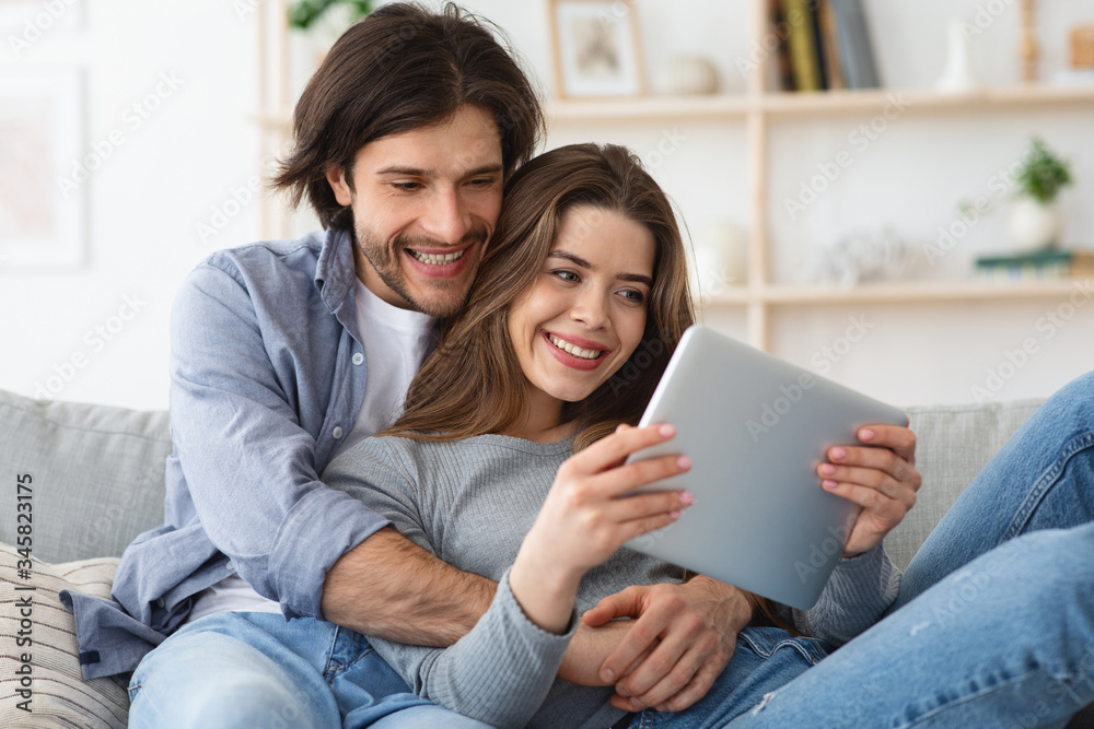 Close up portrait of happy couple using digital tablet together