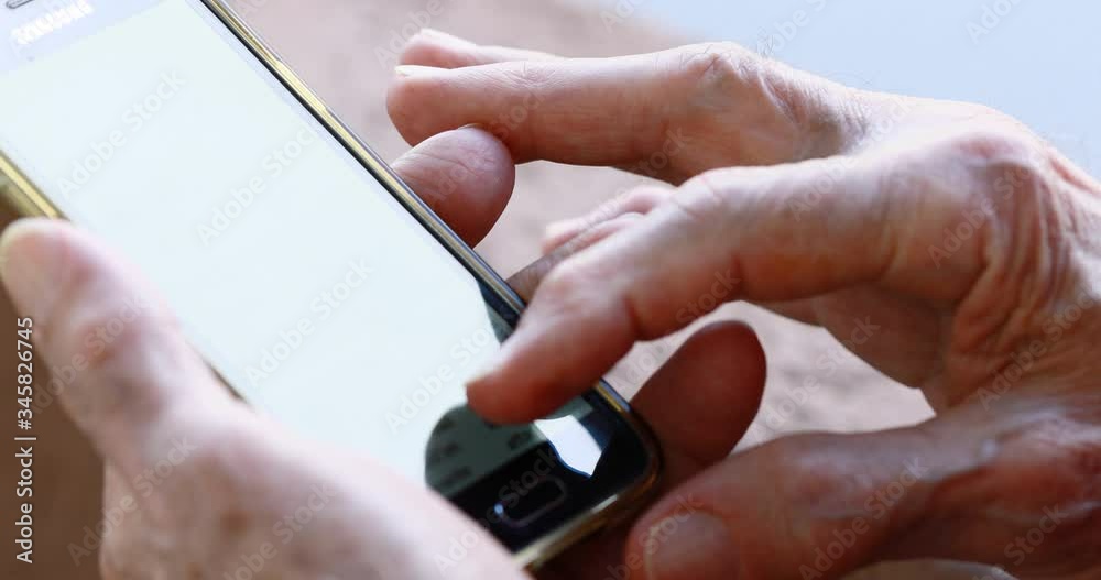closeup of old person's hands handling a smartphone closeup of old person's hands handling a smartphone