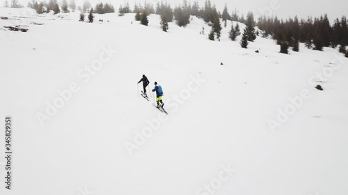 Two People Enjoying Skitouring Climbing A Tough Snowy Terrain In Muntele Mic Carpathian Mountains In Romania - Wide shot photo