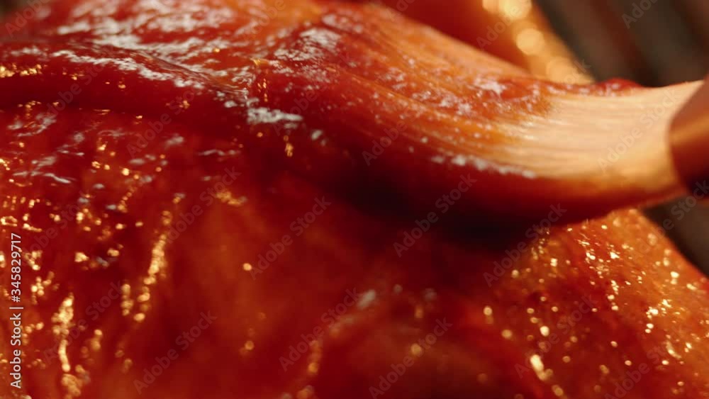 Chicken breast brushed with barbecue sauce in extreme close up