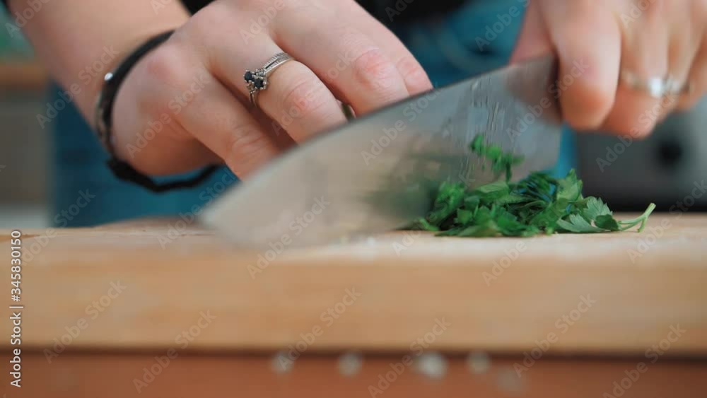 Cutting herbals with a knife while cooking. Cutting herbals with a knife while cooking.