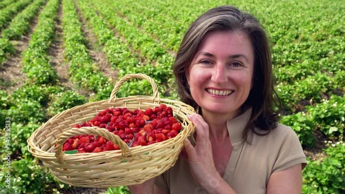 MS Smiling woman holding basket full of woodland strawberries photo