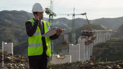 MS Businessman talking on phone at bridge construction site