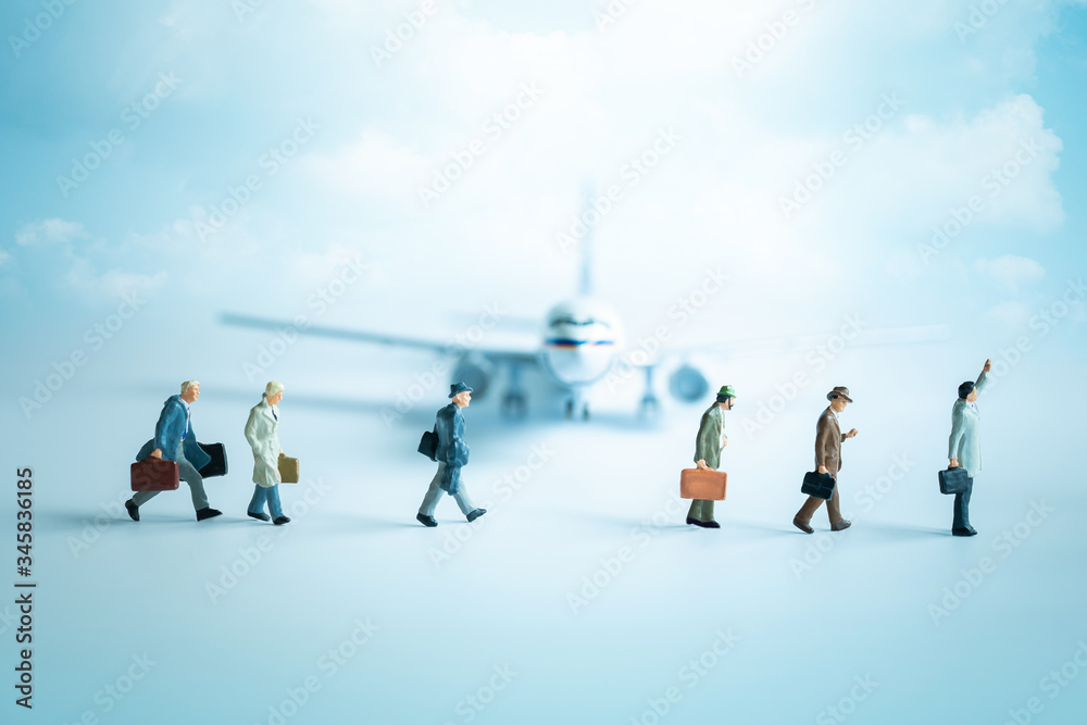 Miniature people, group of travelers standing in front of plane. Air travel and tourism, aviation industry crisis concept. Miniature people, group of travelers standing in front of plane. Air travel and tourism, aviation industry crisis concept.