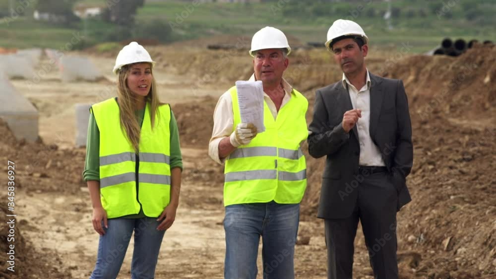 MS Male and female engineers and businessman talking at construction site MS Male and female engineers and businessman talking at construction site