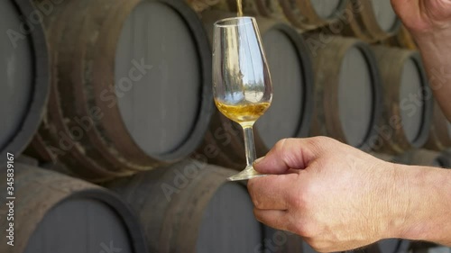 CU Person pouring wine into tasting glass using Sherry sampling tool