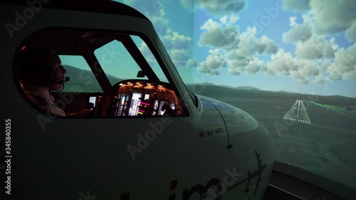 WS Side view of pilots in flight simulator during approach and landing photo