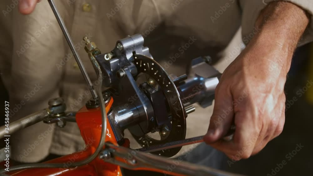 CU Hands of man working with wrench on go-cart brake assembly