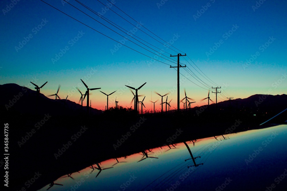wind mills and power lines at sunset