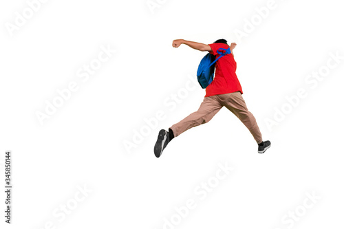 Male student jumping with rucksack in studio