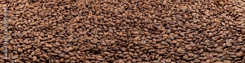 Super large high resolution panorama macro photography of a huge heap of coffee beans. Close up to thousands of roasted coffee beans. Brown roasted beans after roast. Background  wallpaper image