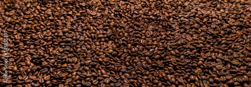 Super large high resolution panorama macro photography of a huge heap of coffee beans. Close up to thousands of roasted coffee beans. Brown roasted beans after roast. Background wallpaper image