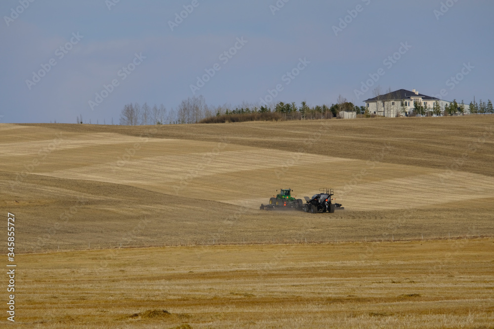 Obraz premium Agricultural tractor in a farm field preparing for planting