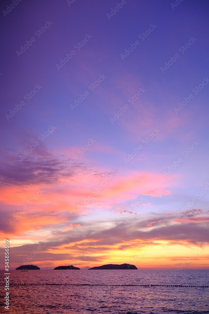 Fototapeta premium Palm tree silhouette on a background of tropical sunset. Beautiful dark orange sky. tropical colorful sky