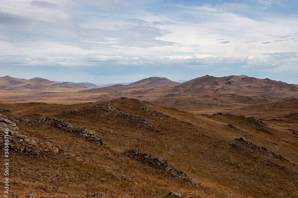 Landscape in a hilly area. Evening brown colors. Clouds in the sky. Landscape in a hilly area. Evening brown colors. Clouds in the sky.