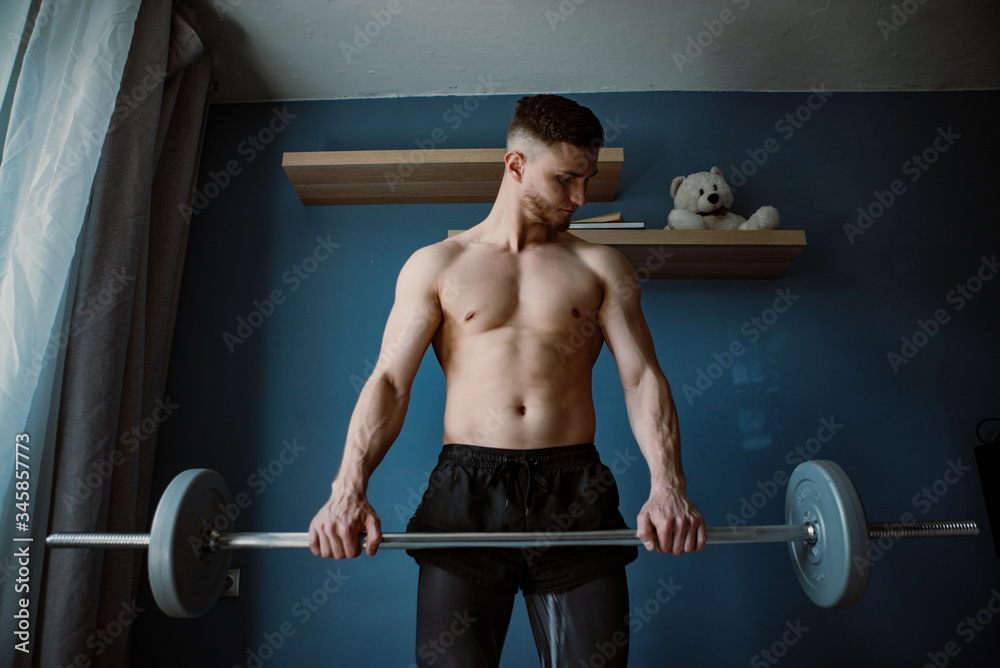 handsome bearded guy exercising with barbell at home handsome bearded guy exercising with barbell at home