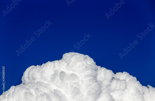 Tablou pe pânză Fluffy hill white clouds in deep blue sky