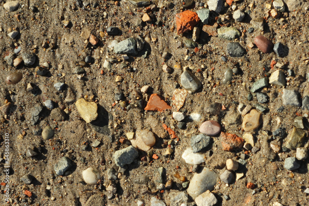 Small stones and sand. The natural texture of the soil. Shore of a reservoir with a beach and pebbles. Small stones and sand. The natural texture of the soil. Shore of a reservoir with a beach and pebbles.