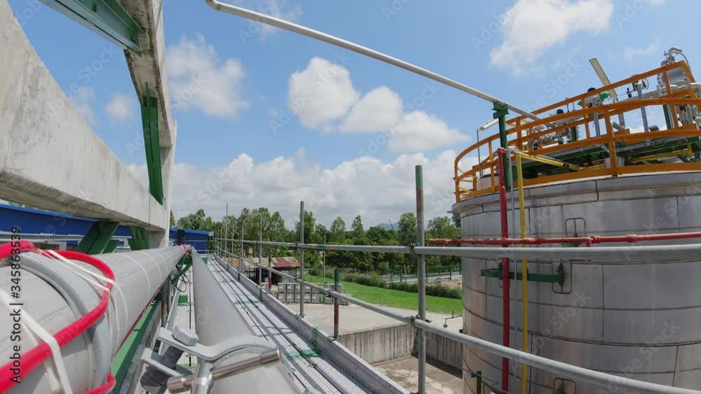 Workers in production plant working at height, wearing a safety harness with an industrial scene in the background, slow motion scene Workers in production plant working at height, wearing a safety harness with an industrial scene in the background, slow motion scene