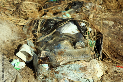 03-05-2020. Syktyvkar, Russia. Heap of garbage with bags, plastic, dry grass, cardboard and bottles. photo
