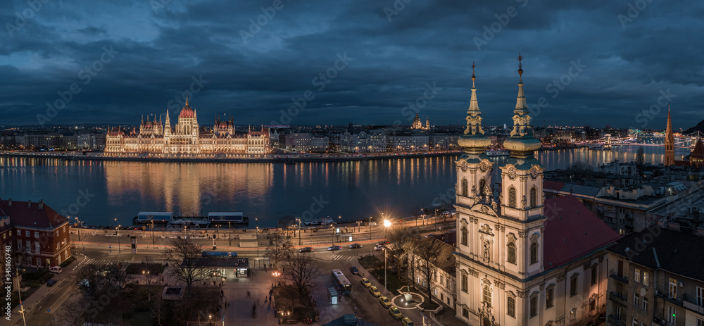 Budapest, Hungary - Aerial view of the Saint Anne Parish Church at Batthyany Square at dusk with illuminated Hungarian Parliament building, St Stephen's Basilica at background