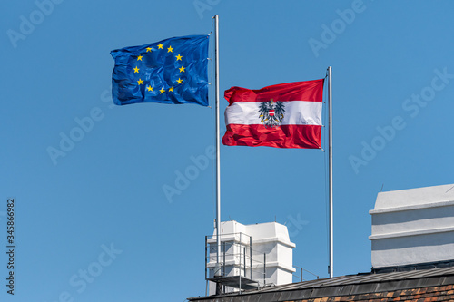 Flags of Austria and the European Union, windy day, blue sky
