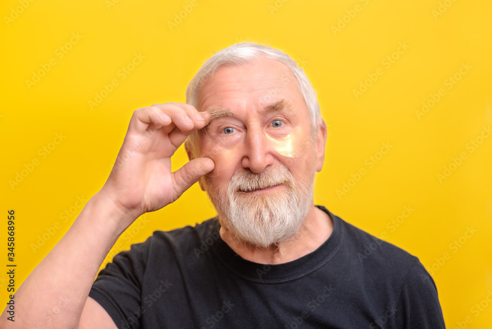 Senior man with eye patch gold and snail showed to it copy space Senior man with eye patch gold and snail showed to it copy space