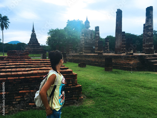 young woman contemplating Thai ruins