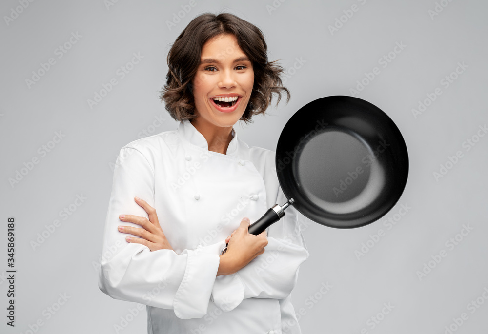 cooking, culinary and people concept - happy smiling female chef in toque with frying pan over grey background cooking, culinary and people concept - happy smiling female chef in toque with frying pan over grey background