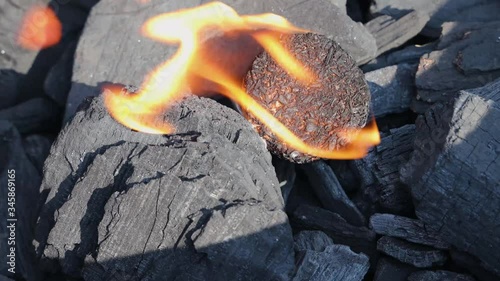 Lit fire starter on lumpwood charcoal in grill - loop photo