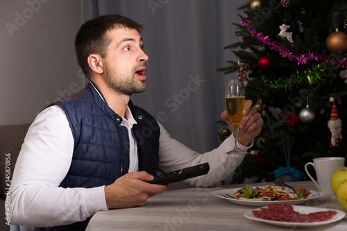 Man having christmas dinner  and watching tv at home