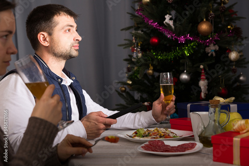 Couple celebrating New Year  and watching tv at dinner