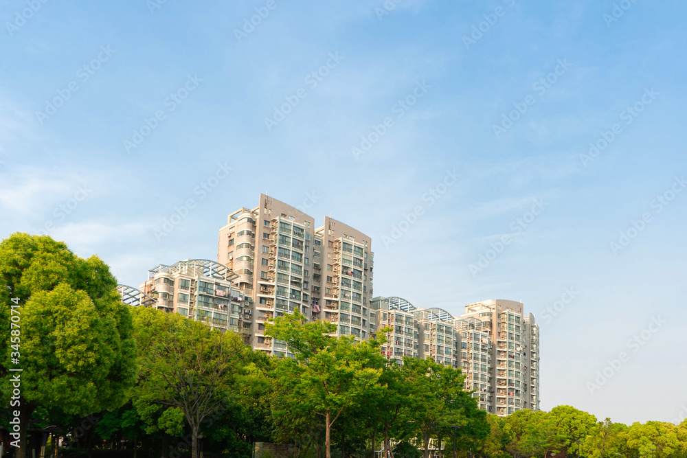 Fototapeta premium The city park under the blue sky. There is upscale residential quarter in the distant.