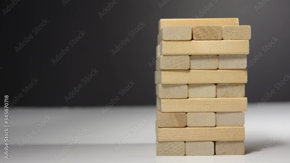 Close up hand holding blocks wood game jenga isolated on white background.