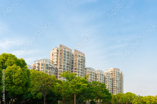 The city park under the blue sky. There is upscale residential quarter in the distant.