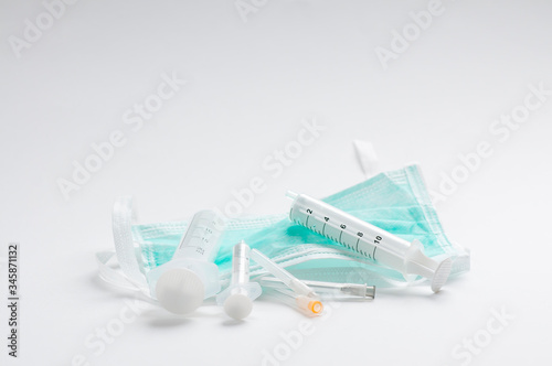 Green protective mmedical, surgical face masc COVID-19. on white background with syringes and needles photo