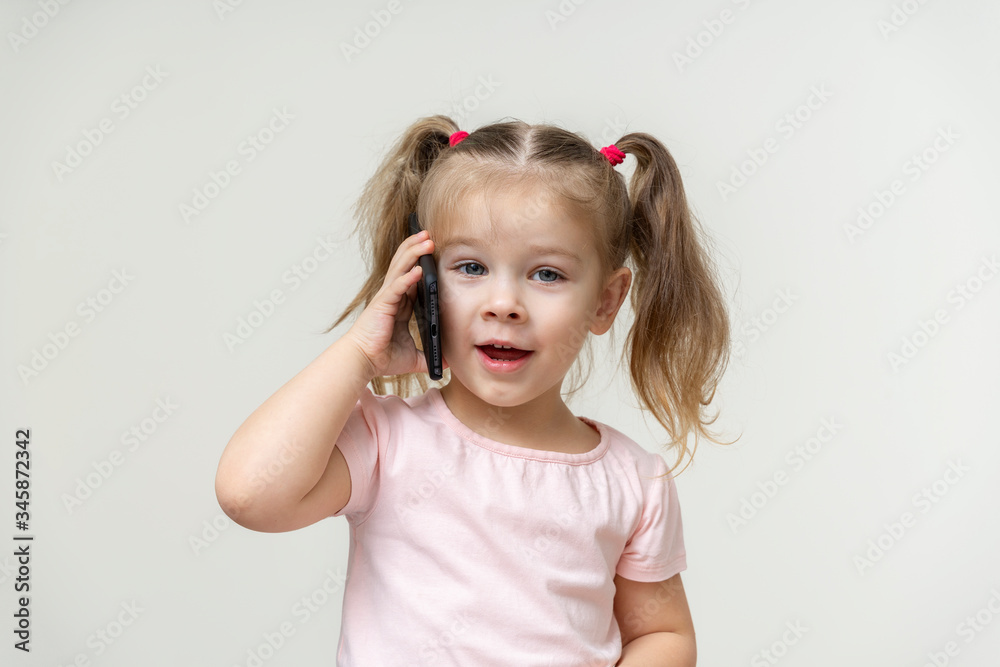 little girl talking by phone outdoor. The concept of addiction of children and gadgets little girl talking by phone outdoor. The concept of addiction of children and gadgets