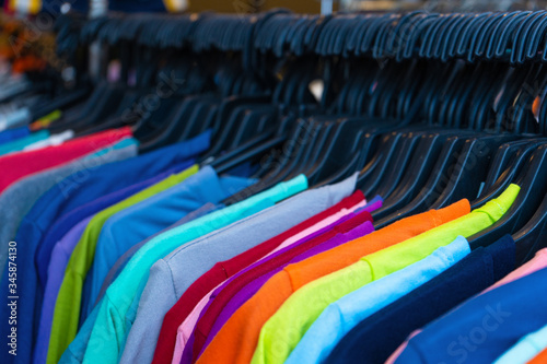 Multi-colored t-shirts on a hanger. Clothing store