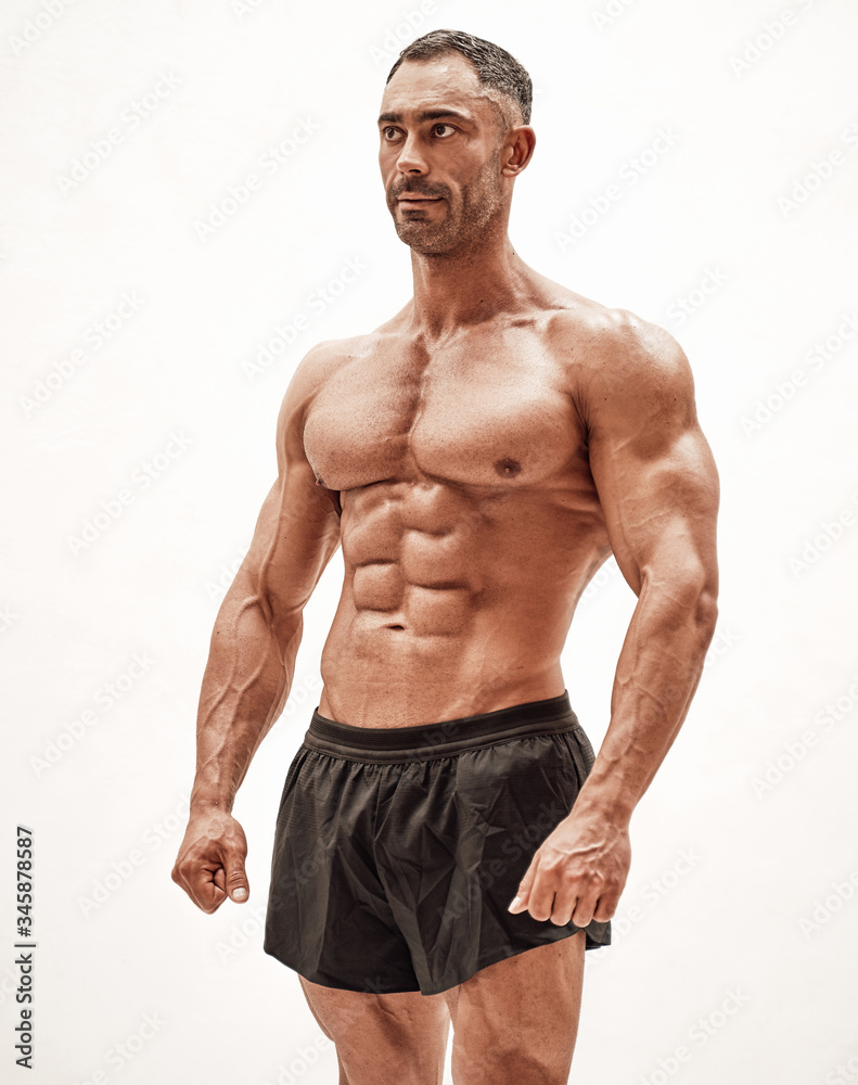 Shirtless sporty caucasian male isolated on a white concrete background