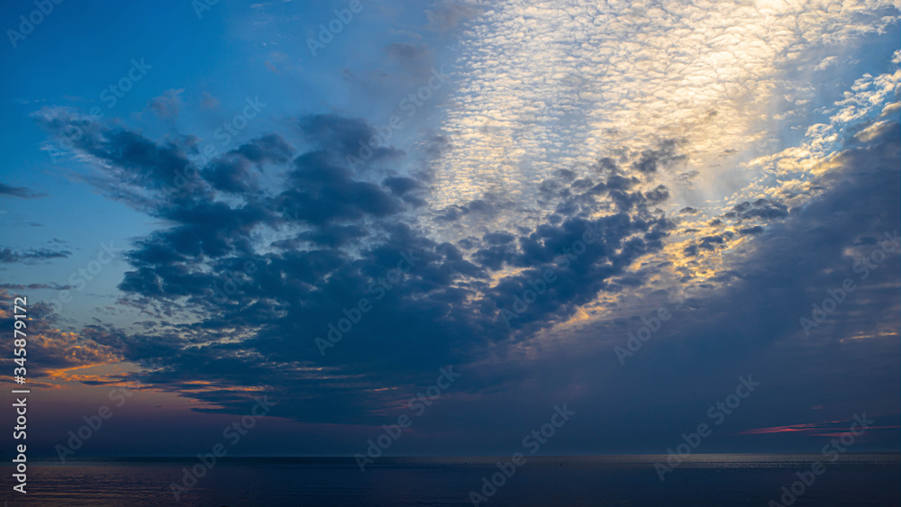 Beautiful scenic sunset over water. Baltic sea. Cloudy weather. Soft focus of sea.